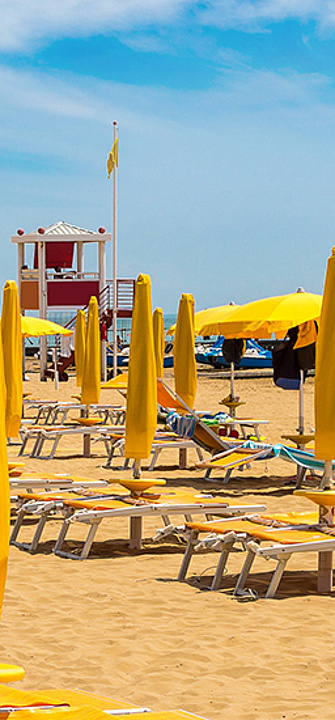 Strand mit gelben Schirmen - Sergii Figurnyi/adobe.stock.com