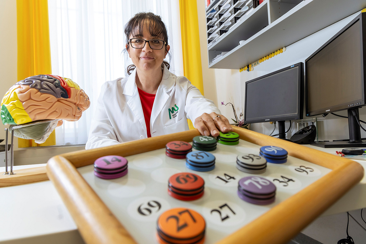 Eine Forscherin sitzt in ihrem Büro und präsentiert einen Test zur Beurteilung der mentalen Kapazitäten.