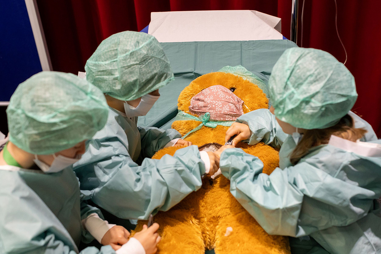 Kinder operieren im Rahmen der Kuscheltierklinik an einem Stofftier