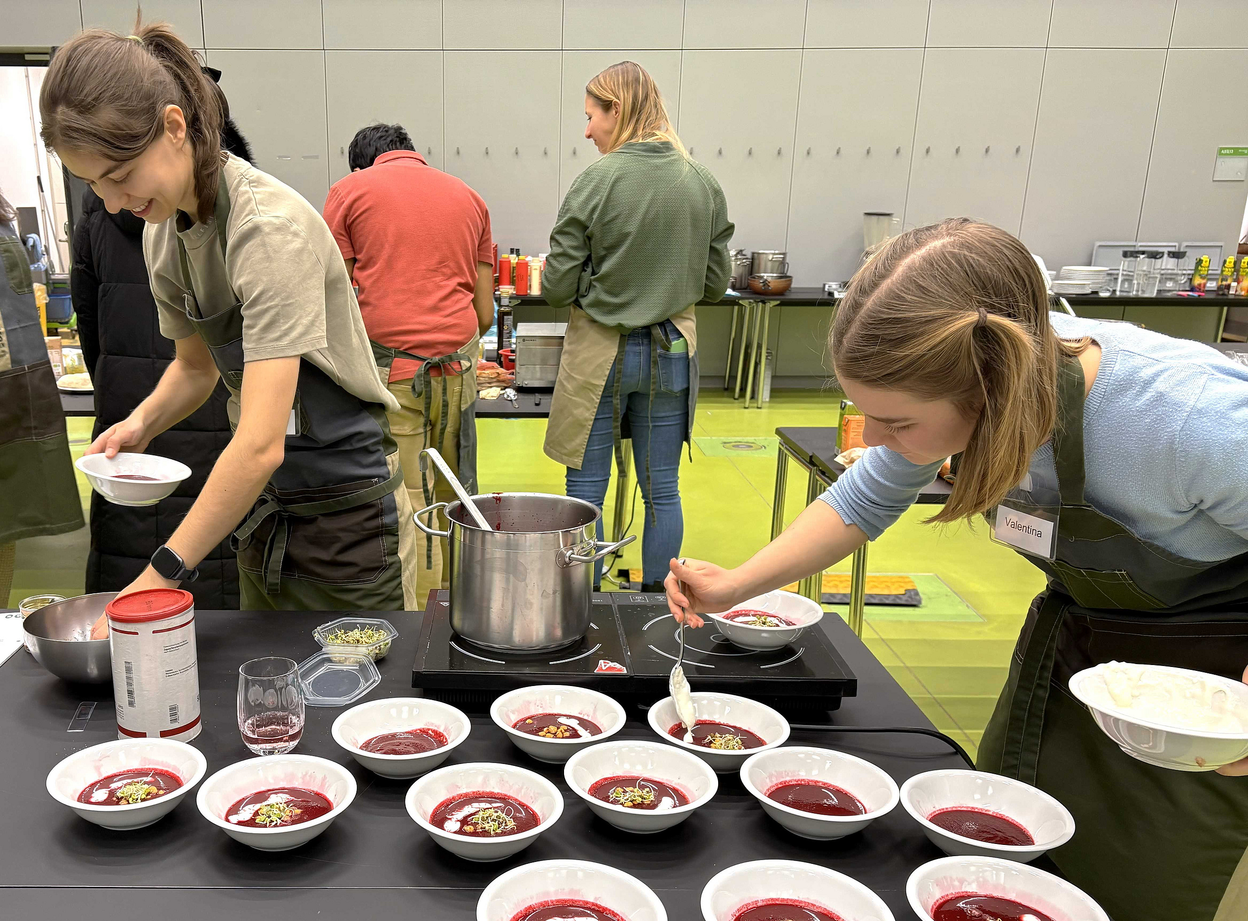 Studierende richten Essen auf Teller an 