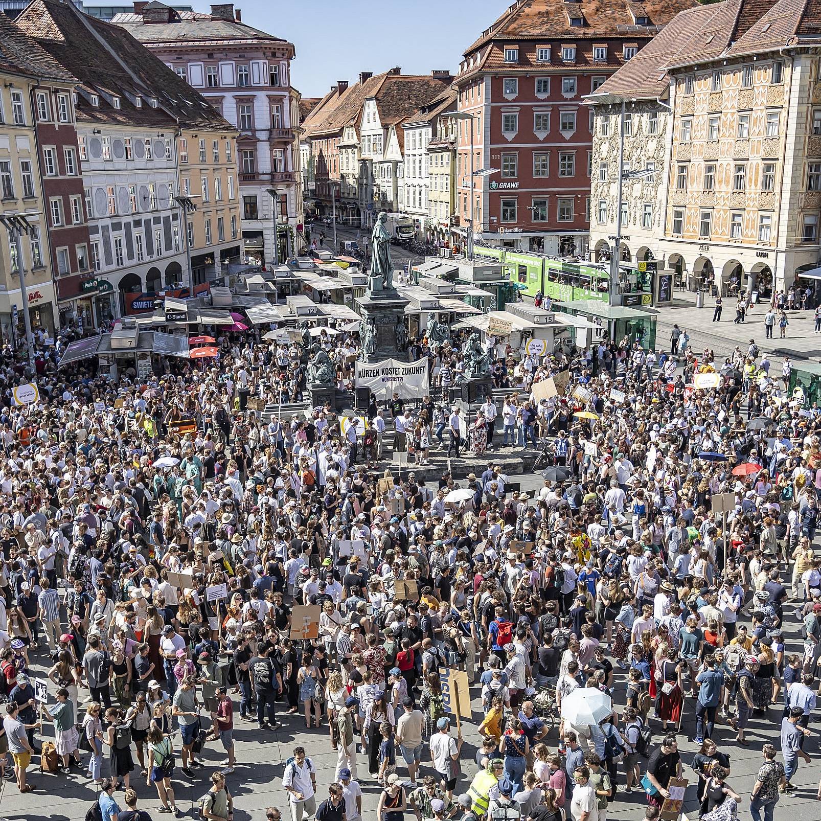 Eine Masse an Menschen versammelt sich um Budgetkürzungen an den Unis zu protestieren.