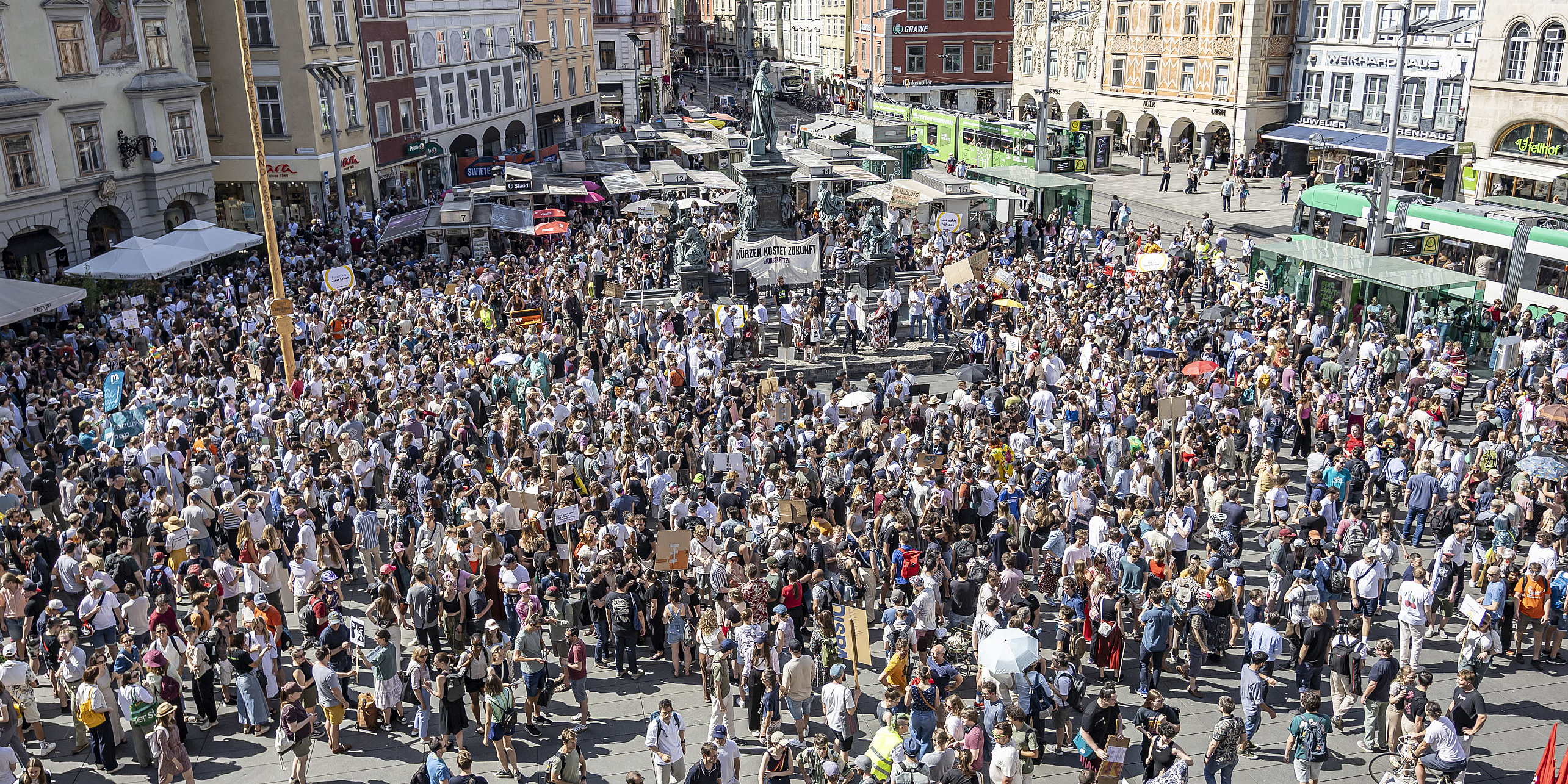 Eine Masse an Menschen versammelt sich um Budgetkürzungen an den Unis zu protestieren.