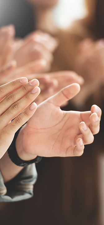 People standing in a row, clapping their hands