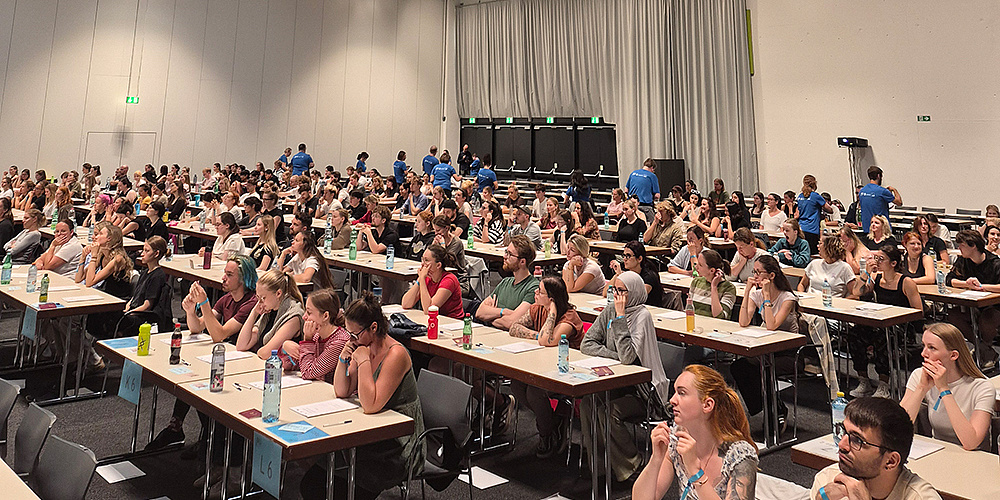 Die Studienwerber*innen für das Psychotherapiestudium sitzen in der Grazer Stadthalle und warten auf den Start des Tests.