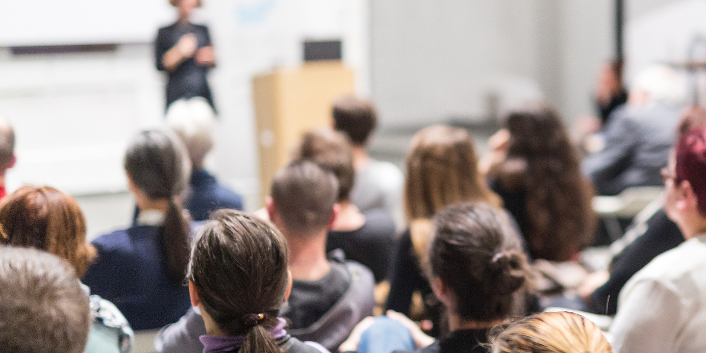Frau hält Vortrag in einem Hörsaal