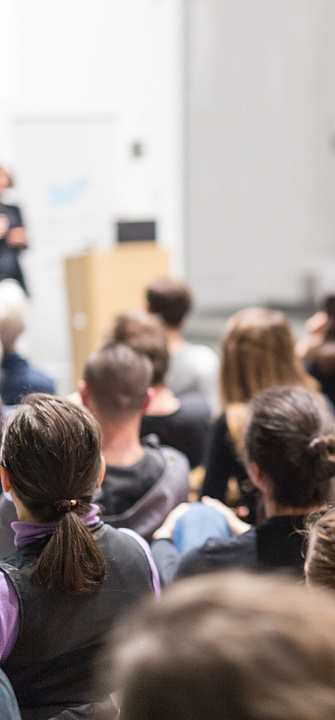 Frau hält Vortrag in einem Hörsaal