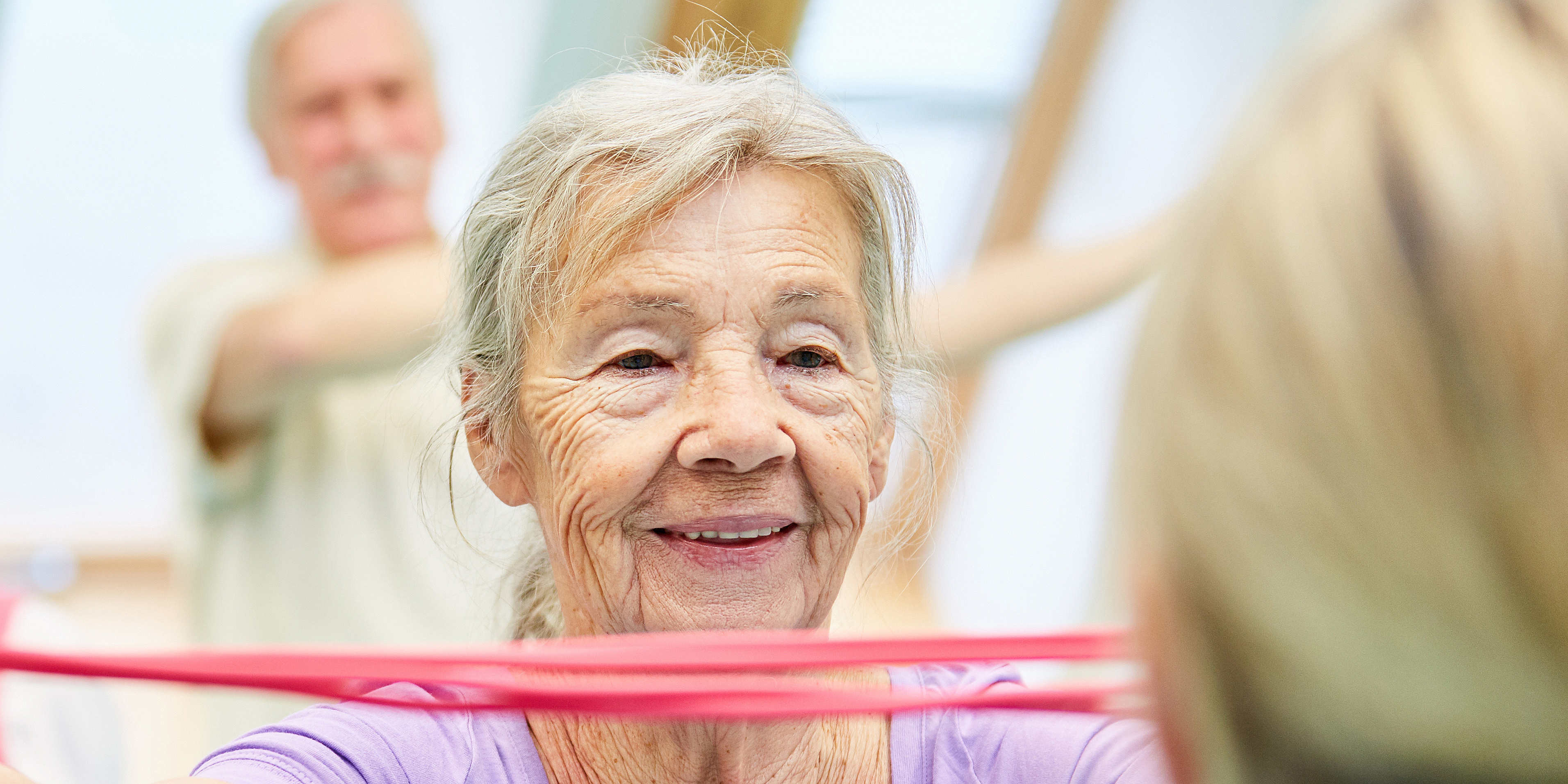 Seniorin bei Gymnastik mi Theraband