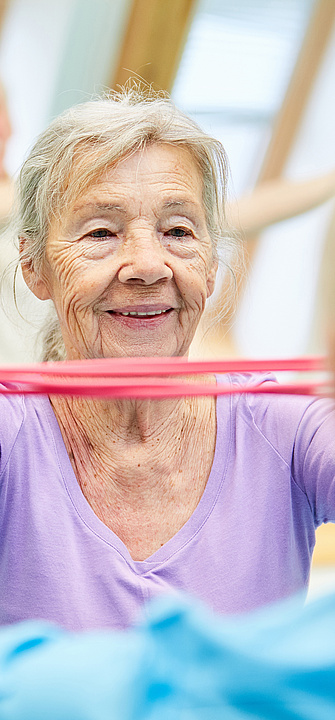 Seniorin bei Gymnastik mi Theraband