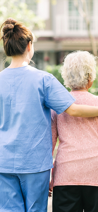 Eine Pflegerin begleitet eine ältere Frau