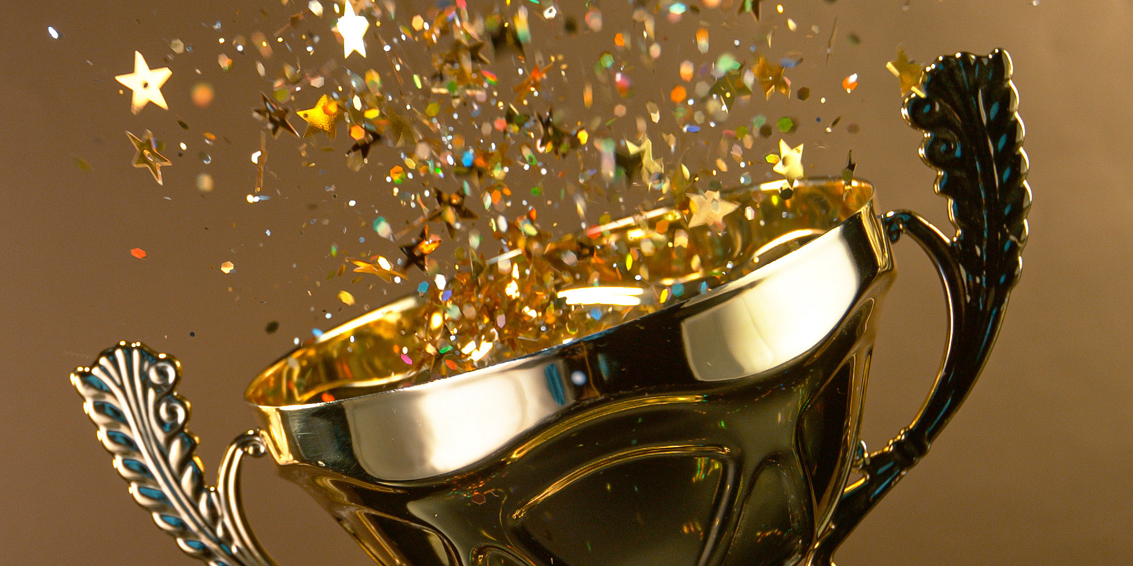 Ein Pokal aus dem Confetti sprüht auf goldenem Hintergrund