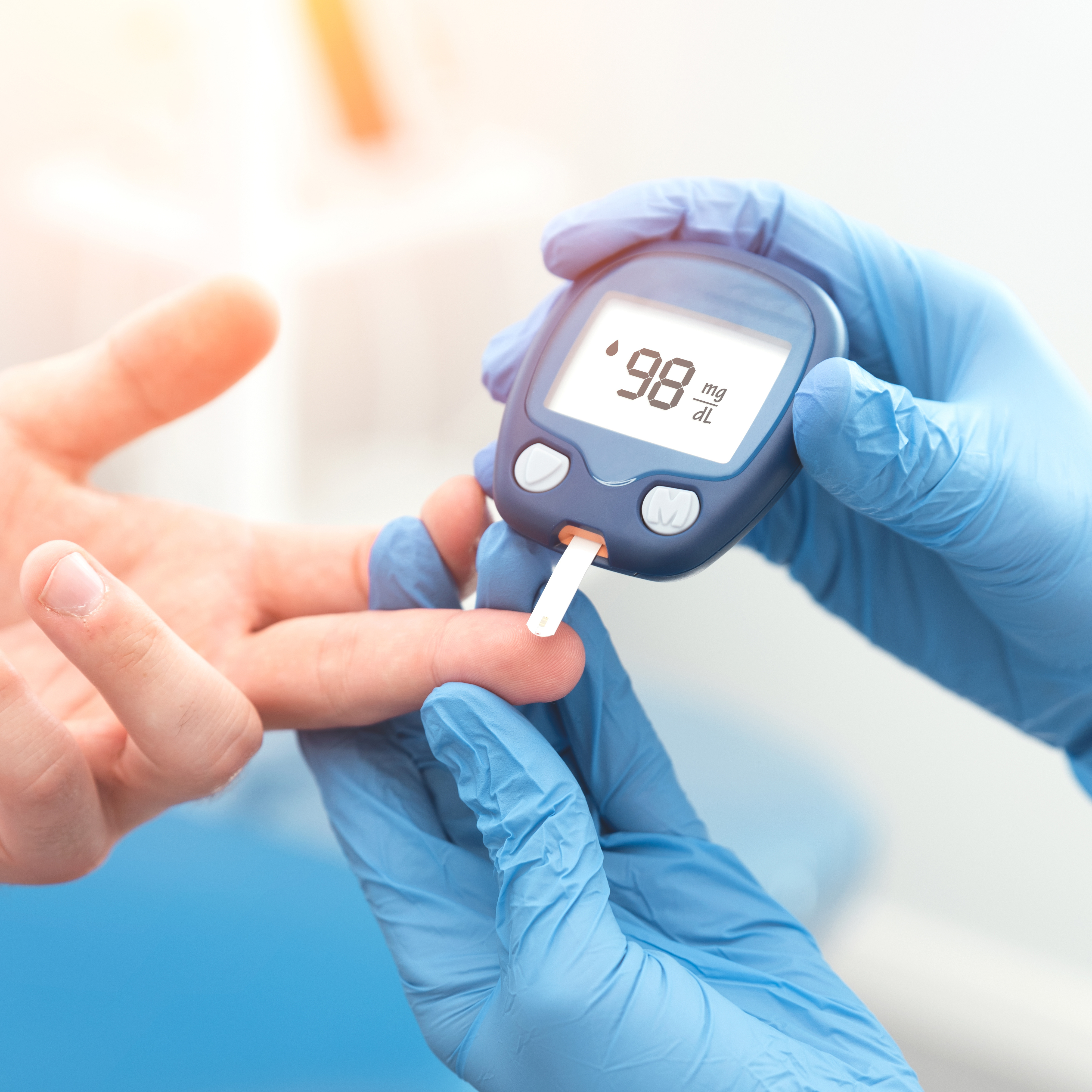 Arzt überprüft Blutzuckerspiegel mit Blutzuckermessgerät