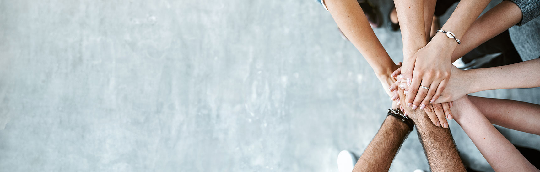 Mehrere Haende auf grauem Hintergrund