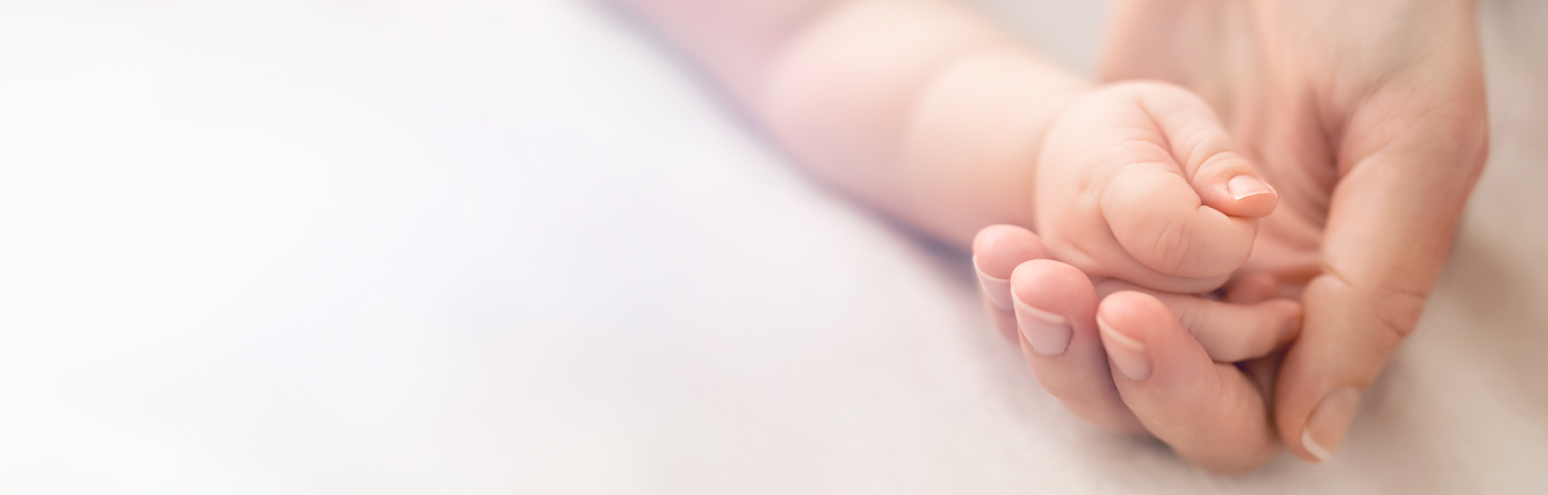 Hand eines Babys liegt in der Hand der Mutter